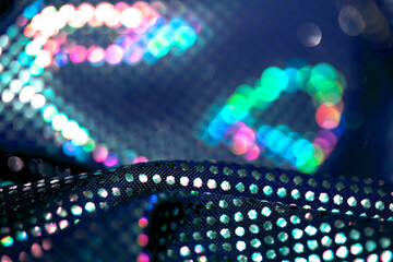 Holographic shiny spots and dots bokeh on fabric for a futuristic disco background
