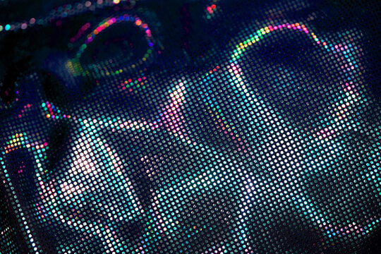 Holographic shiny spots and dots bokeh on fabric for a futuristic disco background