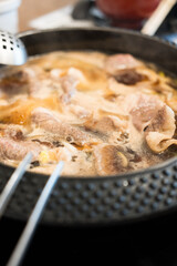 Hot and boiling Shabu soup base in hot pot that fill with beef ready for eating