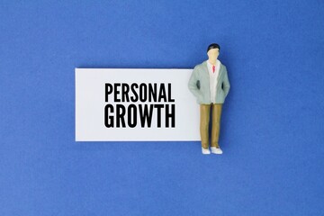 Miniature people and paper with the word personal growth. the ongoing process of developing oneself...