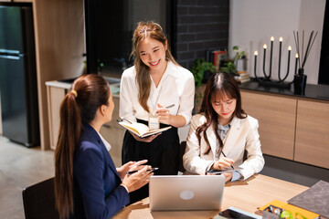 Confident youg businesswoman teaching interns or helping new employees in the organization, using...