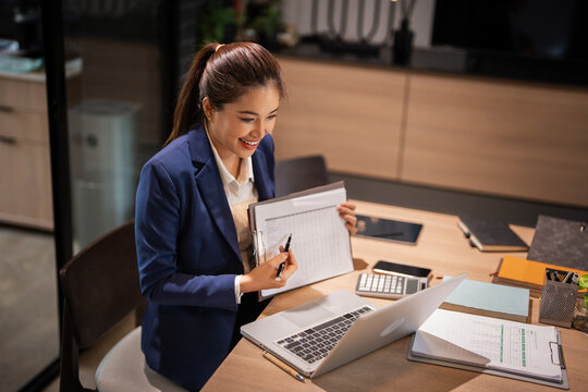 Young Asian businesswoman work at office desk and virtual video conference meeting with colleagues business people, online working, video call .
