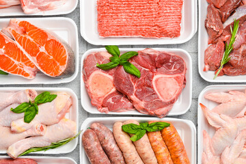 Various raw meat and fish in packaging trays from supermarket. Top view. Food background.