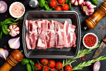 Raw meat. Pork bacon cut into pieces. Meat on a plastic black container from the market. Close-up.
