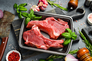 Raw meat. Beef steak on the bone. Meat in a plastic black container from the market. Close-up.