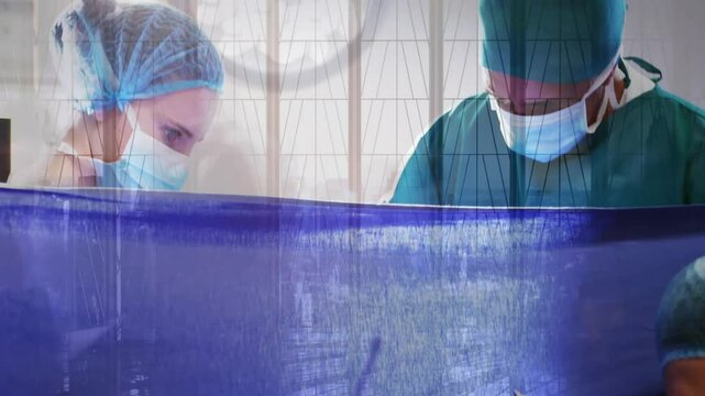 Medical camera panning surgeon cauterizing incision under drape while assistant clearing fluids