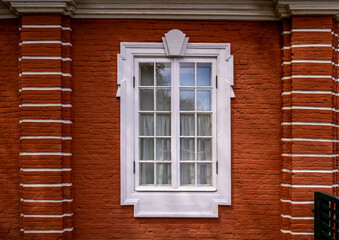 A large wooden window in a brick wall in close-up.