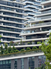 Modern architectural design featuring multiple residential buildings with greenery in urban setting