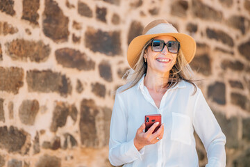 middle-aged adult woman on the street with a mobile phone or smartphone
