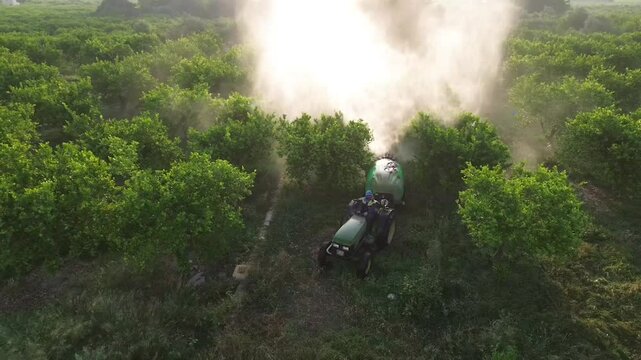 Tractor spraying pesticide drone aerial view, pesticides or insecticide spray on lettuce or iceberg field. Pesticides and insecticides on agricultural field in Spain