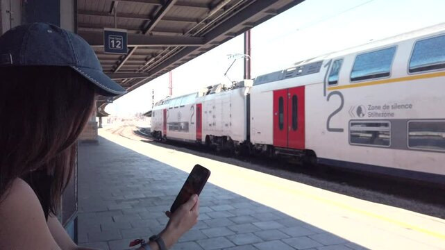 Woman waits as Belgian train passes by platform