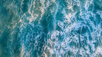 Aerial view over beautiful ocean blue waves crashing