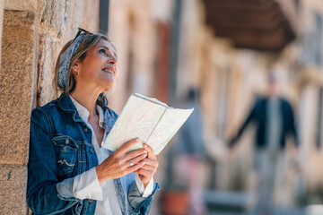 female traveler or tourist on the street with a map