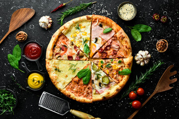 Pizza banner. Set of different pieces of pizza and ingredients on a black stone background. Top...