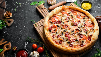 Pizza with Bavarian sausages, mushrooms and cheese. classic pizza On a black stone background. Top view.