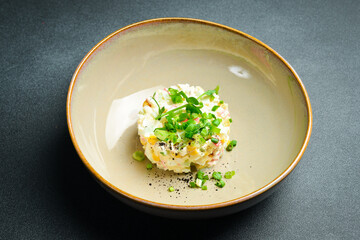 Salad with crab sticks, corn, onion and mayonnaise. On a black stone background. Free space for...