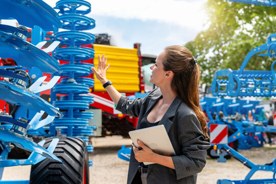 Woman sales representative at dealership presenting farm tools to client farmer