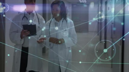 Woman pointing tablet and doctor tapping while walking hospital hallway generating network overlay