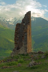 Ancient architecture and ruins against mountain background . Remains of a destroyed tower . North...