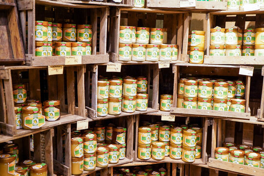 Wooden box shelves stacked full with organic honey jars, home made, market store shelves