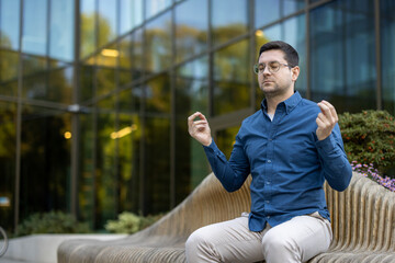 A man meditates outdoors in front of a modern building, promoting mindfulness and mental wellness....