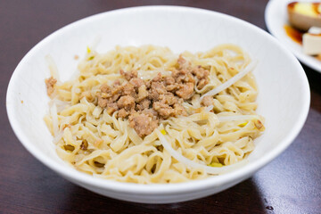 A bowl of Taiwanese-style dry noodles topped with savory minced pork sauce, scallions, and soy-based seasoning. A beloved comfort food offering rich umami and chewy texture.