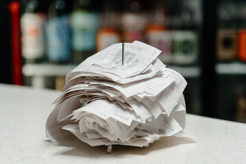 pile of spiked papers, restaurant and bar checks with orders on bar counter