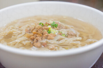 A comforting bowl of Taiwanese minced pork noodles served in a light savory broth. Tender noodles soak up the flavorful soup, topped with green onions and soy-braised pork, making it a perfect rainy d