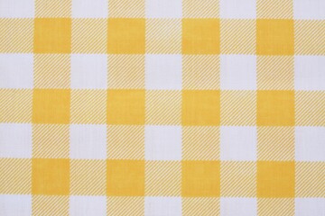 Closeup of a yellow and white checkered napkin or tablecloth texture. picnic cloth crumpled. Food...