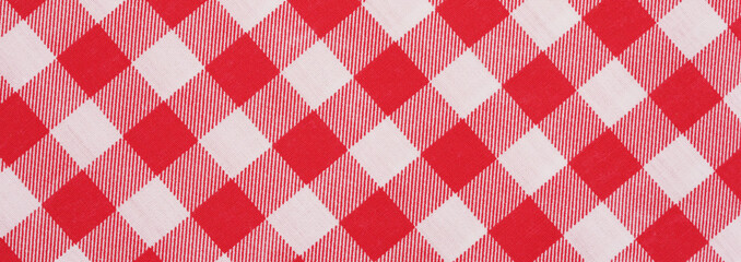 Closeup of a red and white checkered napkin or tablecloth texture. picnic cloth crumpled. Food decor element. Kitchen accessories. Top view background.