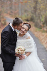 A bride and groom are kissing each other on a road