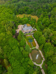 An aerial view of a historic mansion surrounded by lush green trees and a beautifully landscaped...
