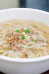 A comforting bowl of Taiwanese minced pork noodles served in a light savory broth. Tender noodles soak up the flavorful soup, topped with green onions and soy-braised pork, making it a perfect rainy d
