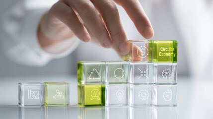 Translucent glass blocks with sustainability icons and circular economy text are being arranged by hand