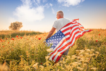 A proud man wrapped in the American flag stands in a golden field of wildflowers under a vibrant sky, symbolizing patriotism, freedom, and connection to the land