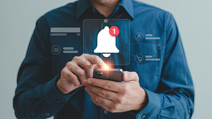 Man in blue shirt using smartphone with notification bell icon and social media icons mobile phone