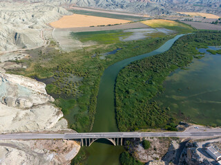 Nallihan Bird Sanctuary Ankara Turkey Aerial View of a Bridge Spanning a River Through Lush Landscape. High-angle, full shot of a bridge gracefully arching over a flowing river, weaving through divers