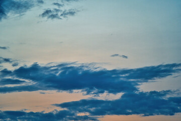 Western sky at sunset. A relaxing scene of day's end with gentle clouds stretching across the horizon. Shades of blue and orange