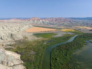 Nallıhan Kus Cenneti Nallihan Bird Sanctuary Aerial View of a Winding River through Colorful Desert Landscape. An expansive aerial shot showcasing a river snaking through a colorful desert landscape.
