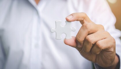 Person holds a puzzle piece, symbolizing solution, strategy, and conceptual thinking
