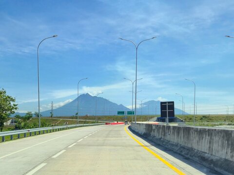 A photo of mount merapi from afar taken while on a highway in central Java