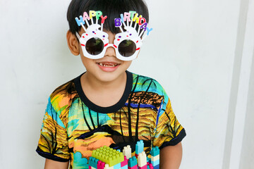Happy Boy Wearing Birthday Glasses with Building Blocks