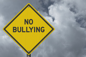 No Bullying yellow warning sign with stormy cloudy sky