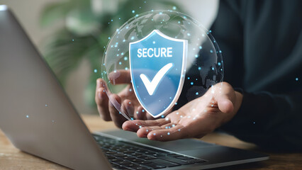 Person holding a digital shield for cybersecurity over a laptop, showing protection and security for data and privacy in a connected world with the internet.