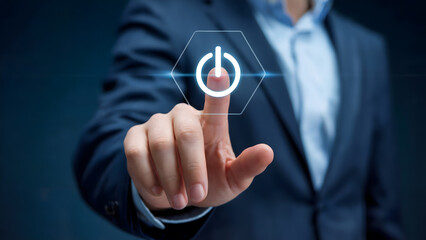 A man's hand in a suit presses a glowing power button, symbolizing innovation, new beginnings, and the start of a technological process with energy and advancement.
