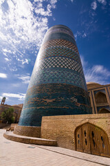 Low angle view of Kalta Minor Minaret in Khiva, Uzbekistan. Iconic turquoise tower against blue sky, showcasing traditional Islamic architecture.