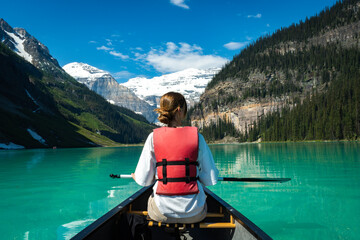 Woman canoeing on calm turquoise lake