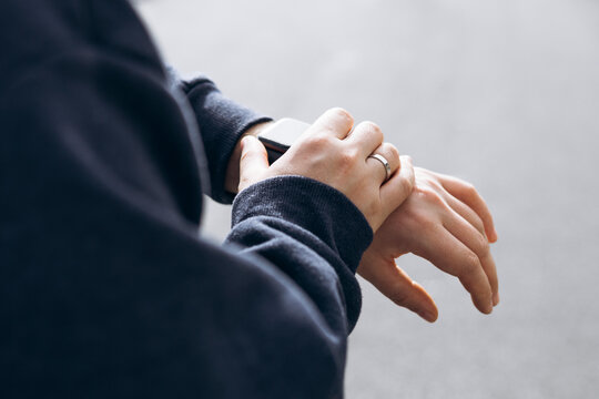 Close-up of male hand checking smartwatch outdoors. Modern wearable technology.