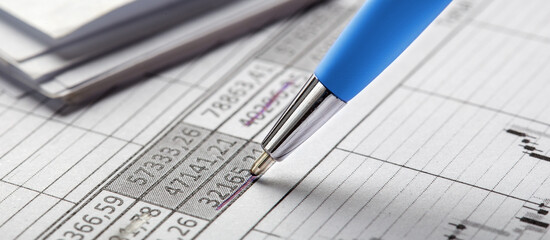 Accounting document with pen, money, coins and checking financial chart. Concept of banking, financial report and financial audit.