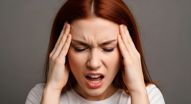 Intense Headache: Woman Gripping Temples, Expressing Pain, Red Hair.